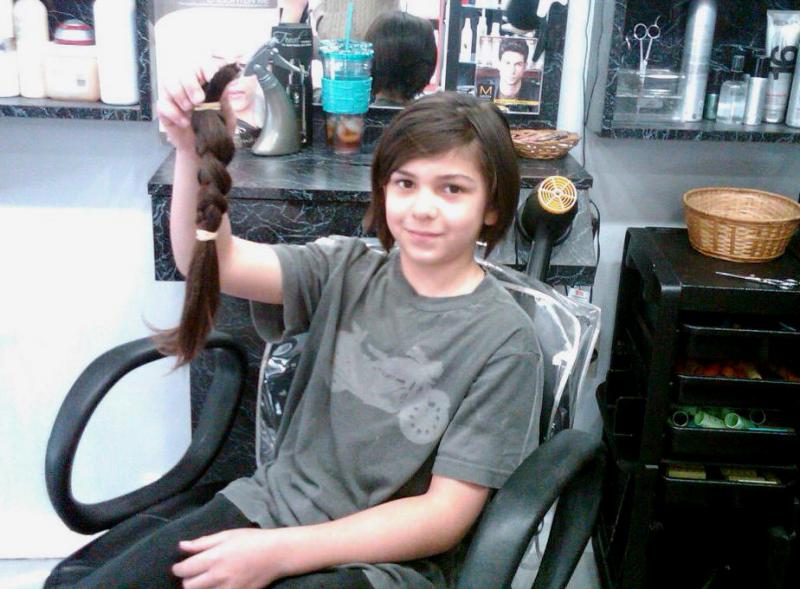 Avery Gilbert after getting his hair cut at Hair Boutique II in Buzzards Bay. Gilbert donated more than 10" of his hair to "Wigs for Kids," a non profit that supports kids who have lost hair as a result of medical conditions or burn accidents, after growing it out for almost 4 years. COURTESY DAWN GILBERT